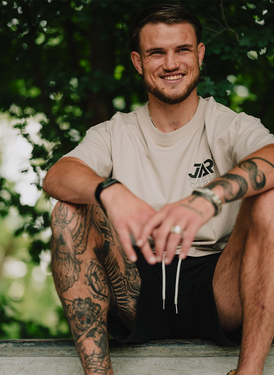 Coach posing outside while smiling